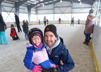 child with dad on skating rink
